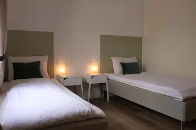 two beds in a room with two lights on them at Valldal Gjestgiveri in Valldal