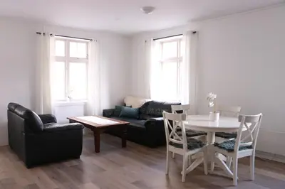 a living room with a table and chairs and a couch at Valldal Gjestgiveri in Valldal