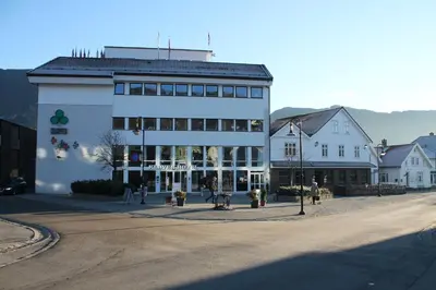a large white building on the side of a street at Kløver Hotel in Sauda