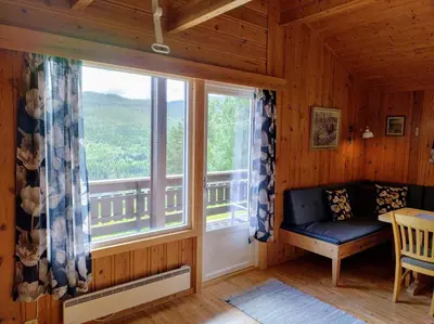 a room with a window with a bench and a table at Hogstul Hytter - Apartment South in Tuddal