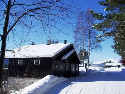 a barn covered in snow on a snowy street at Hogstul Hytter - Apartment South in Tuddal
