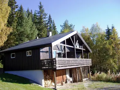 a large black house with a large deck at Hogstul Hytter - Apartment North in Tuddal
