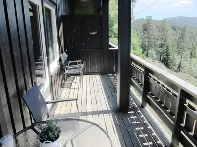 a balcony of a cabin with a table and chairs at Hogstul Hytter - Apartment North in Tuddal