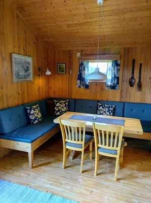 a dining room with a bench and a table and chairs at Hogstul Hytter - Apartment North in Tuddal