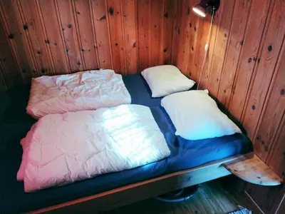 two beds in a room with wooden walls at Hogstul Hytter - Apartment North in Tuddal