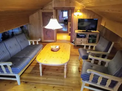 a living room with a table and a couch and a tv at Hogstul Hytter - Gamlestua in Tuddal