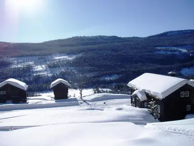 a couple of buildings covered in snow at Hogstul Hytter - Gamlestua in Tuddal