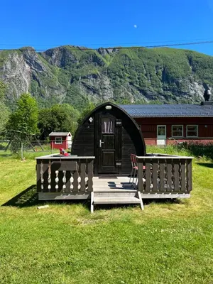 a gazebo with a table and benches in the grass at Vistdal Camping in Myklebostad