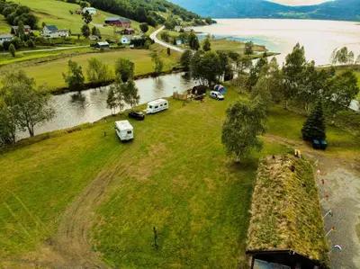 an aerial view of vehicles parked on a field next to a river at Vistdal Camping in Myklebostad