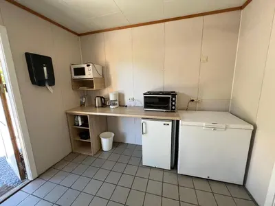 a small kitchen with a refrigerator and a microwave at Vistdal Camping in Myklebostad