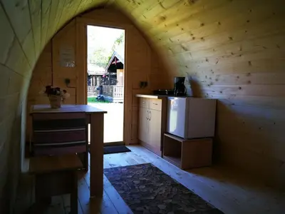 a kitchen in a wooden cabin with a counter and a refrigerator at Vistdal Camping in Myklebostad