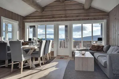 a living room with a table and chairs and a couch at Tinden Grendehytte in Beitostøl