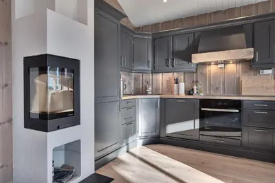 a kitchen with gray cabinets and a stove at Tinden Grendehytte in Beitostøl