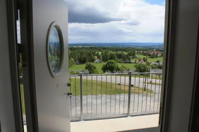 a door to a balcony with a view of a field at Hedmarktoppen in Hamar