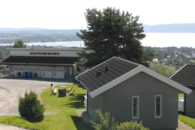a small gray building in front of a building at Hedmarktoppen in Hamar