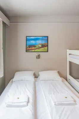 two beds in a room with white sheets at Austbø Hotell in Rauland