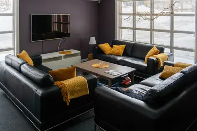 a living room with black leather couches and a table at Austbø Hotell in Rauland