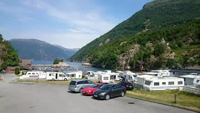 a group of cars parked in a parking lot next to a lake at Kyrping Camping in Kyrping