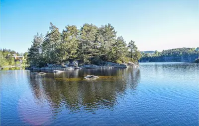 a large lake with trees in the middle of it at Stunning Home In Haulandshella in Tveitevåg