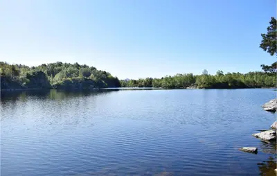 a large body of water with trees in the background at Stunning Home In Haulandshella in Tveitevåg