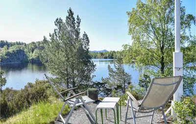 two chairs and a table with a view of a lake at Stunning Home In Haulandshella in Tveitevåg