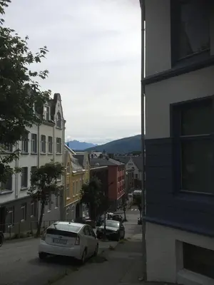 a city street with buildings and a car parked at Ålesund downtown loft room with shared bathroom in Ålesund