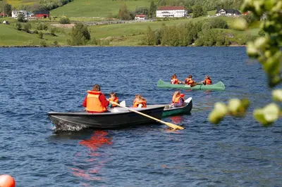 a group of people in boats on a lake at Lyngmo Hytter in Hafslo