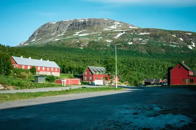 a village with red buildings and a mountain at Maristova apartment 110 in Filefjell