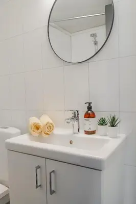 a white bathroom with a sink and a mirror at Maristova apartment 110 in Filefjell