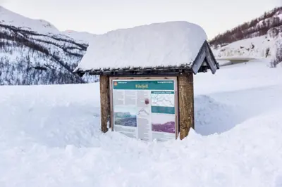 a snow covered sign in the middle of a snow covered field at Maristova apartment 110 in Filefjell