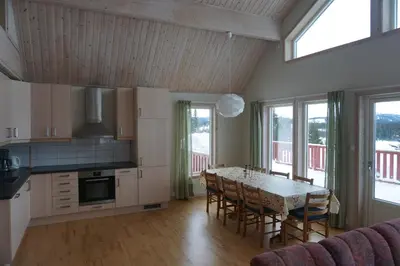 a kitchen with a table and chairs and some windows at Totakbu in Rauland