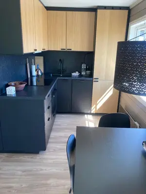 a kitchen with wooden cabinets and a table with chairs at Oppdal Alpintun in Oppdal