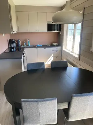 a kitchen with a black table and chairs at Oppdal Alpintun in Oppdal