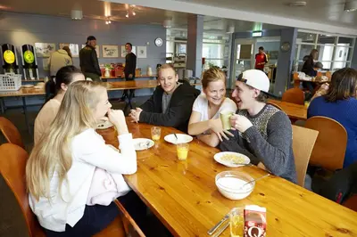 a group of people sitting at a table in a restaurant at Hardanger Hostel B&B in Lofthus