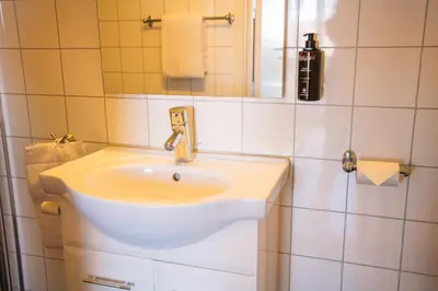 a bathroom with a white sink and a mirror at Solund Leileghetshotell in Hardbakke