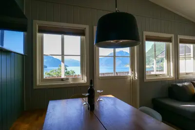 a dining room table with a bottle of wine on it at Kinsarvik Camping in Kinsarvik