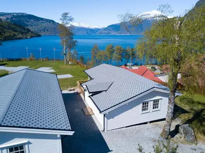 an aerial view of a house with a lake at Kinsarvik Camping in Kinsarvik