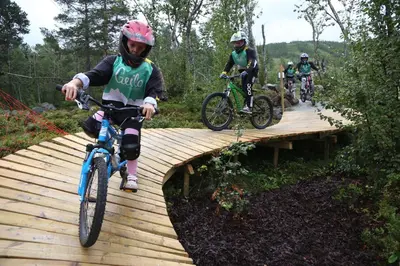 a group of people riding bikes on a wooden bridge at Torsetlia Cottages and Apartments in Uvdal