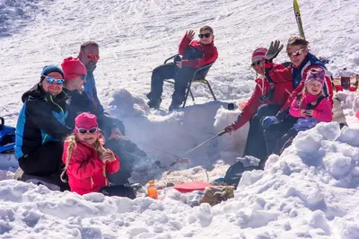 a group of people sitting around a fire in the snow at Torsetlia Cottages and Apartments in Uvdal