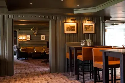 a restaurant with tables and chairs and a dining room at Geilo Hotel in Geilo