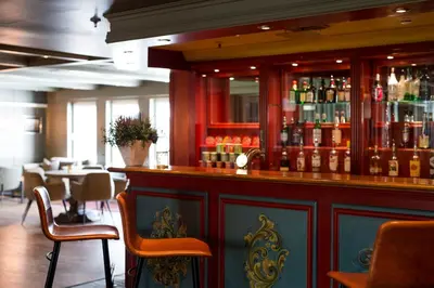a bar in a restaurant with tables and chairs at Geilo Hotel in Geilo