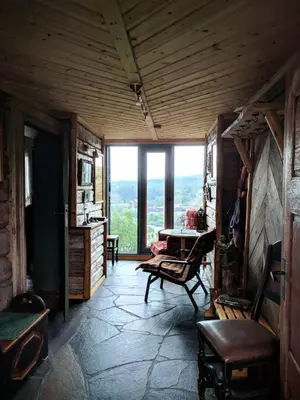 a living room with a table and a large window at Ivaregga Vinterstua in Tolga