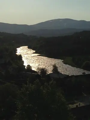 a view of a river with trees and mountains at Ivaregga Vinterstua in Tolga