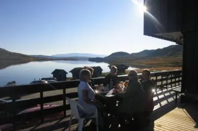 a group of people sitting at a table on a deck at Bergsjøstølen Fjellstue in Bergsjostolen
