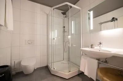 a bathroom with a glass shower and a sink at Knutholmen in Kalvåg