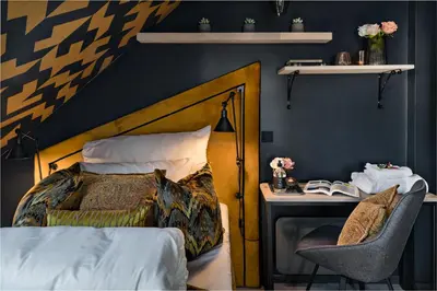 a bedroom with a bed and a desk with a chair at Knutholmen in Kalvåg