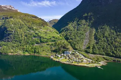 an island in the middle of a body of water at Geirangerfjorden Feriesenter in Geiranger