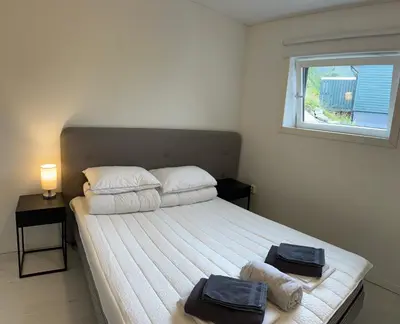 a bedroom with a bed with two towels on it at Jolster sauna apartments in Skei