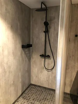 a shower with a shower head in a bathroom at Jolster sauna apartments in Skei