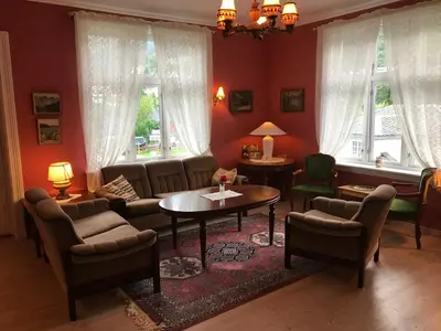 a living room with a couch and chairs and a table at Villa Holmen in Balestrand
